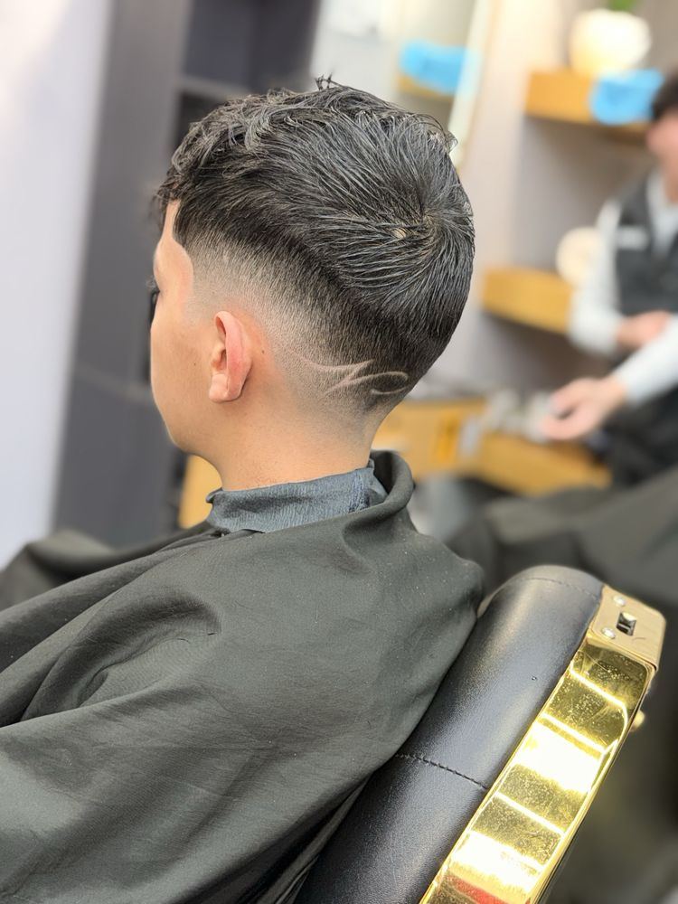 Low fade with a razor-cut line design, seen from the back